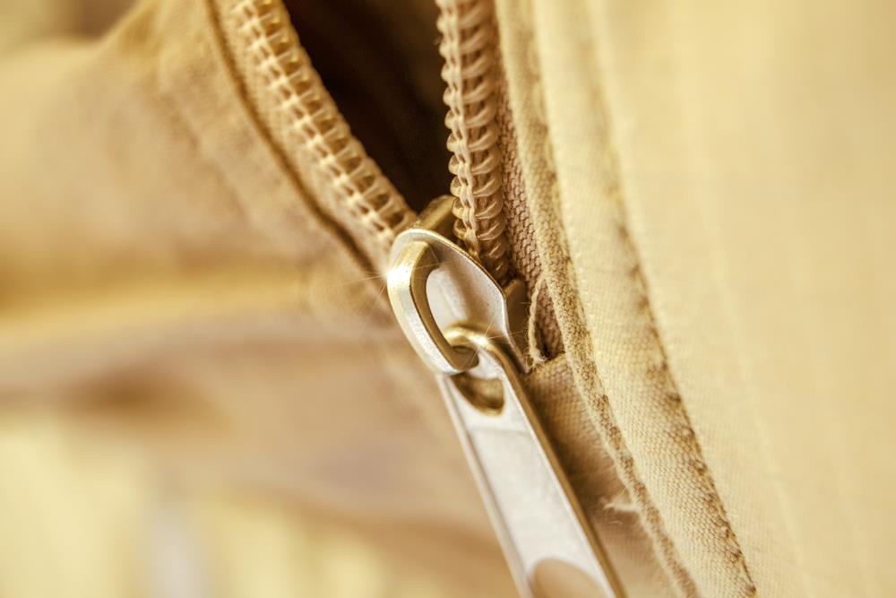 Close-up of a metal zipper in a thick material with heavy seams
