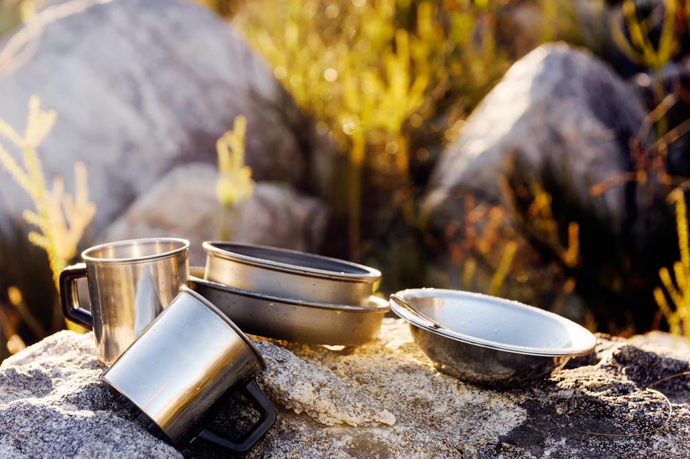 backpacking-cookware-pot-bowl-pan-mug-and-utensils-outdoor-in-the-morning-sunlight