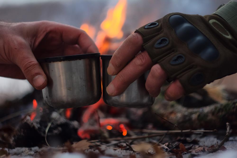 drinking coffee beside campfire