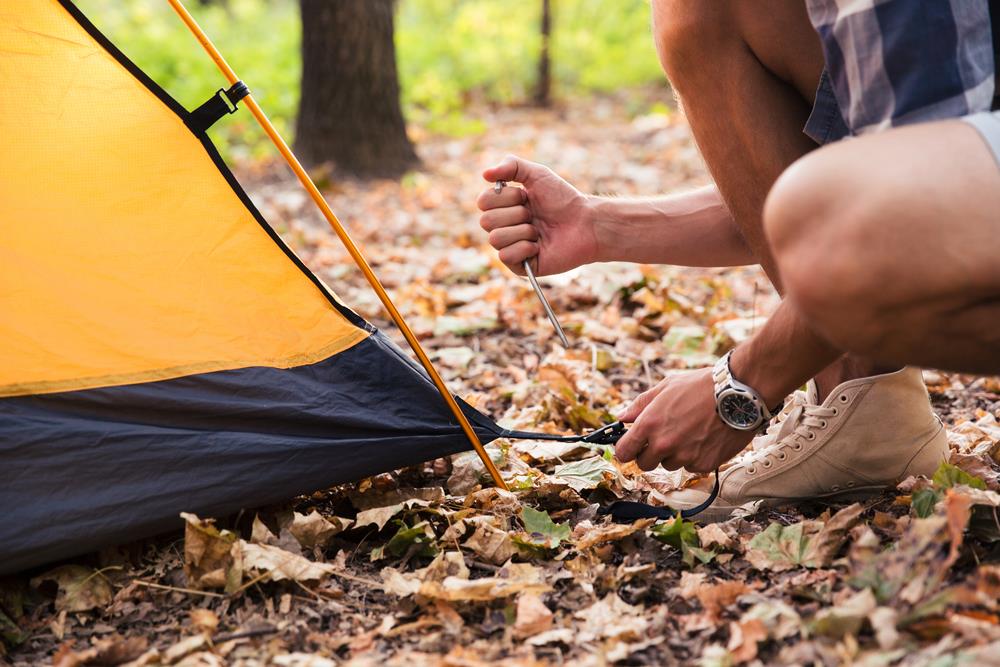 Portrait of a man setting up a tent on a camping trip
