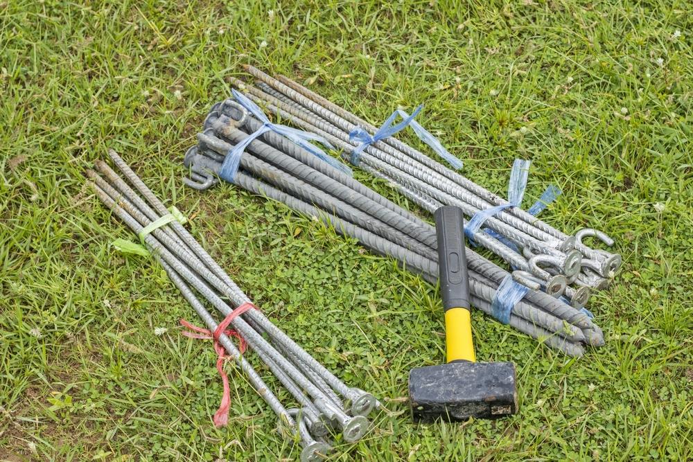 tent pegs and Hammer on grass field - holidays