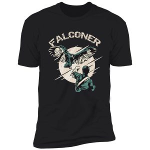 falconry bird landing on falconer arm shirt